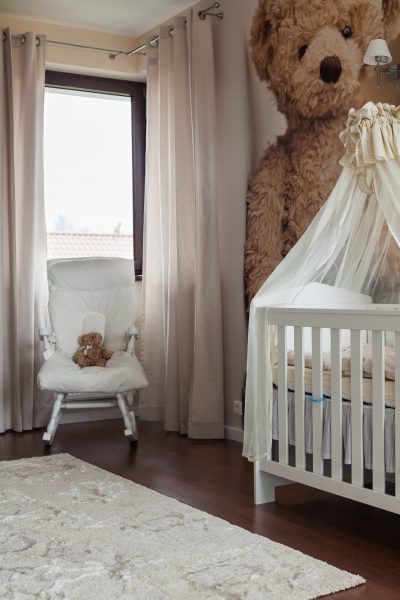 Photo of cute toddler room with white cradle
